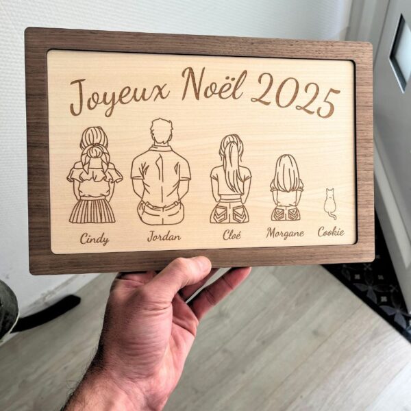 Cadre famille en bois artisanal à personnaliser, gravé "Joyeux Noël 2025" avec quatre silhouettes et un chat et prénoms. | Cadeau personnalisé en bois | Bibam Bois
