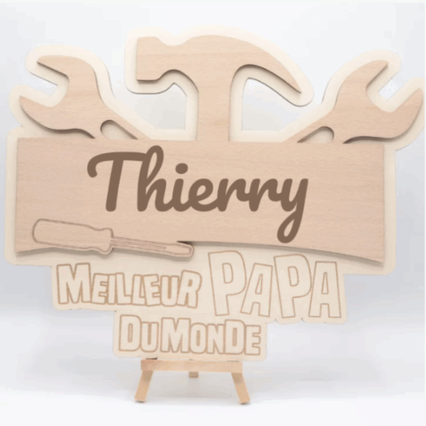Plaque en bois artisanale personnalisée avec outils gravés, prénom et "Meilleur Papa du Monde", posée sur un chevalet. | Cadeau personnalisé en bois | Bibam Bois