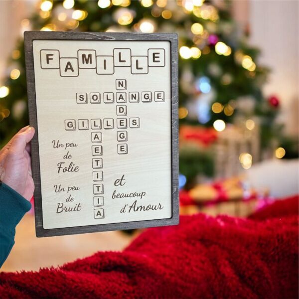 Cadre en bois artisanal personnalisé avec lettres type Scrabble formant "FAMILLE", présenté dans une ambiance festive de Noël. | Cadeau personnalisé en bois | Bibam Bois